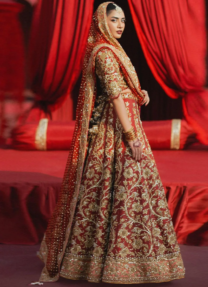 Red 14-kali Walima lehenga with attached cancan, deep V choli and gold, rose-gold and silver work