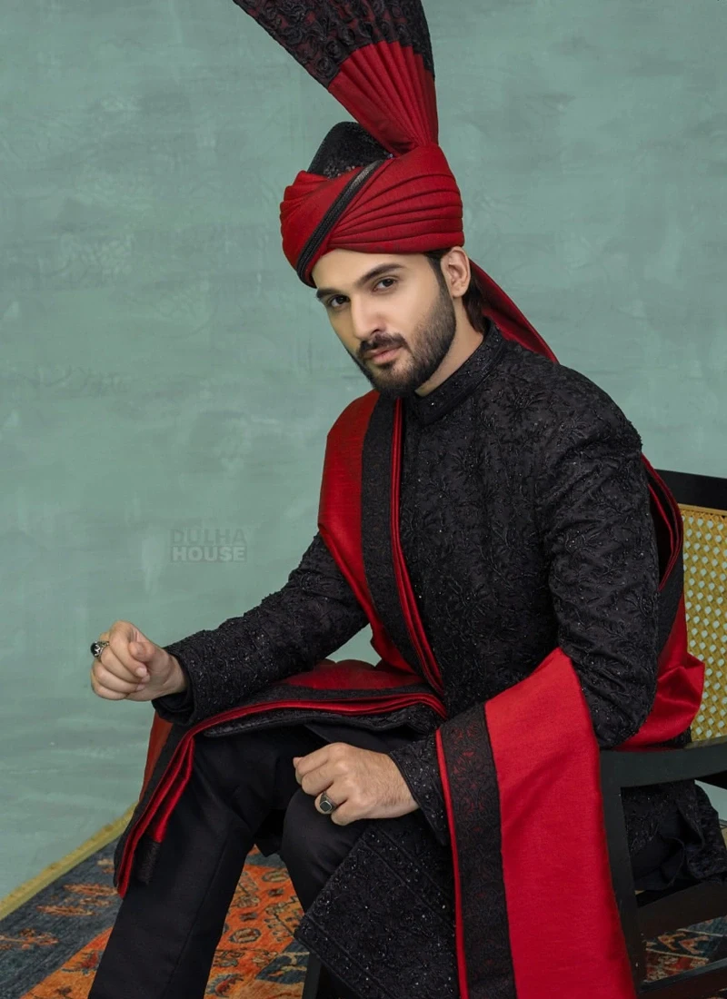 Pakistani black sherwani for groom with red turban and coordinated shawl for wedding ceremonies