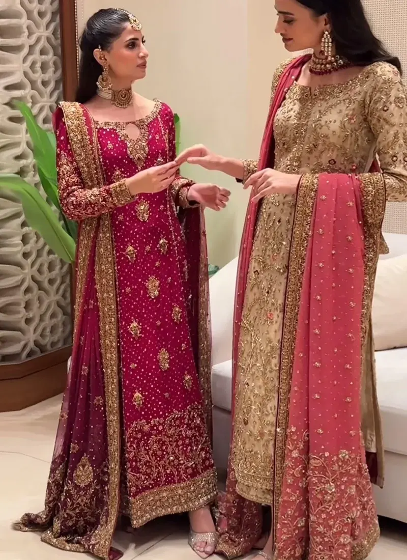 Ruby red formal dress featuring intricate gold zardozi hand embroidery and traditional Pakistani detailing