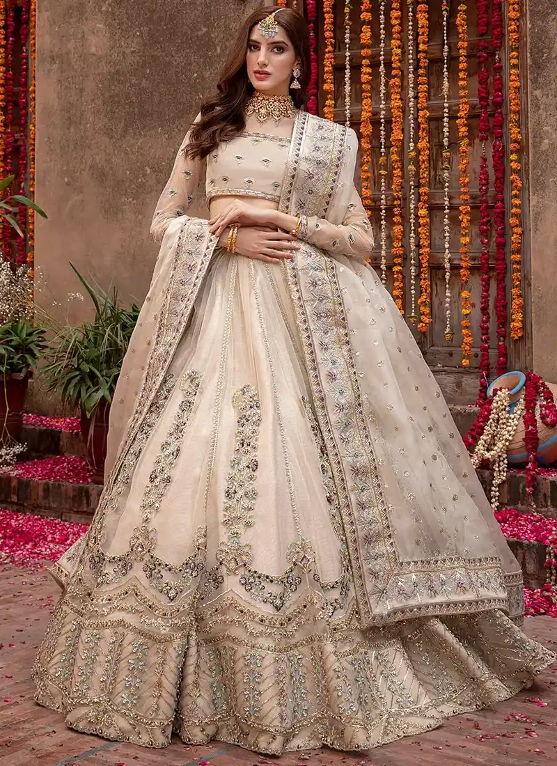 Champagne Walima Lehenga Choli with Scalloped Floral Arches Champagne Walima lehenga choli, full-length front view with scalloped floral arches and ornate embroidered hem