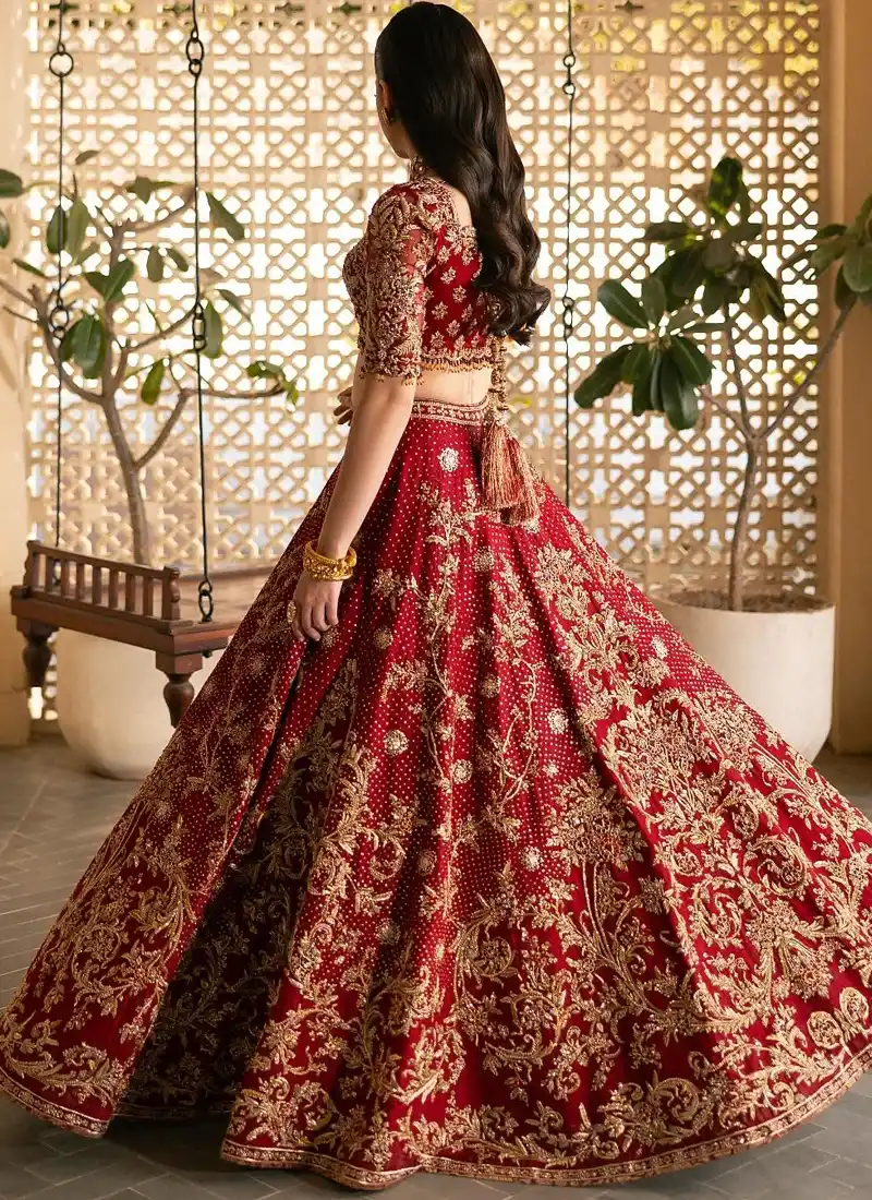 Deep red bridal lehenga choli front view with sweetheart blouse, gold floral skirt and sheer embroidered dupatta