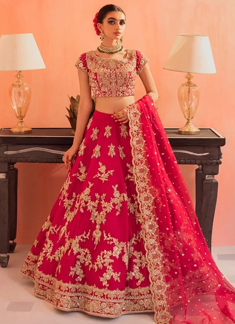 Fuchsia bridal choli close-up showing a square neckline, cap sleeves and intricate gold embroidery