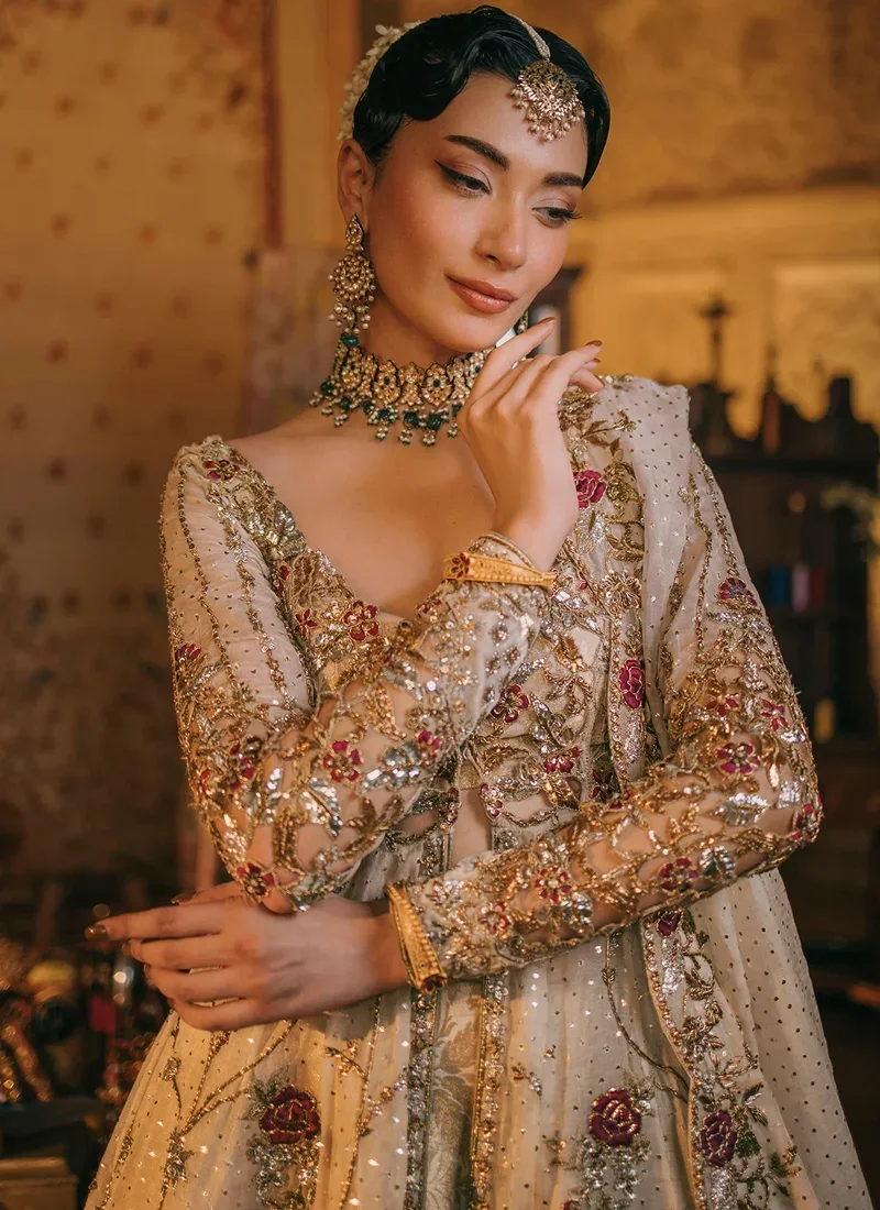 Ivory open gown with lehenga, side view featuring a sheer antique-red dupatta and scalloped red velvet hem