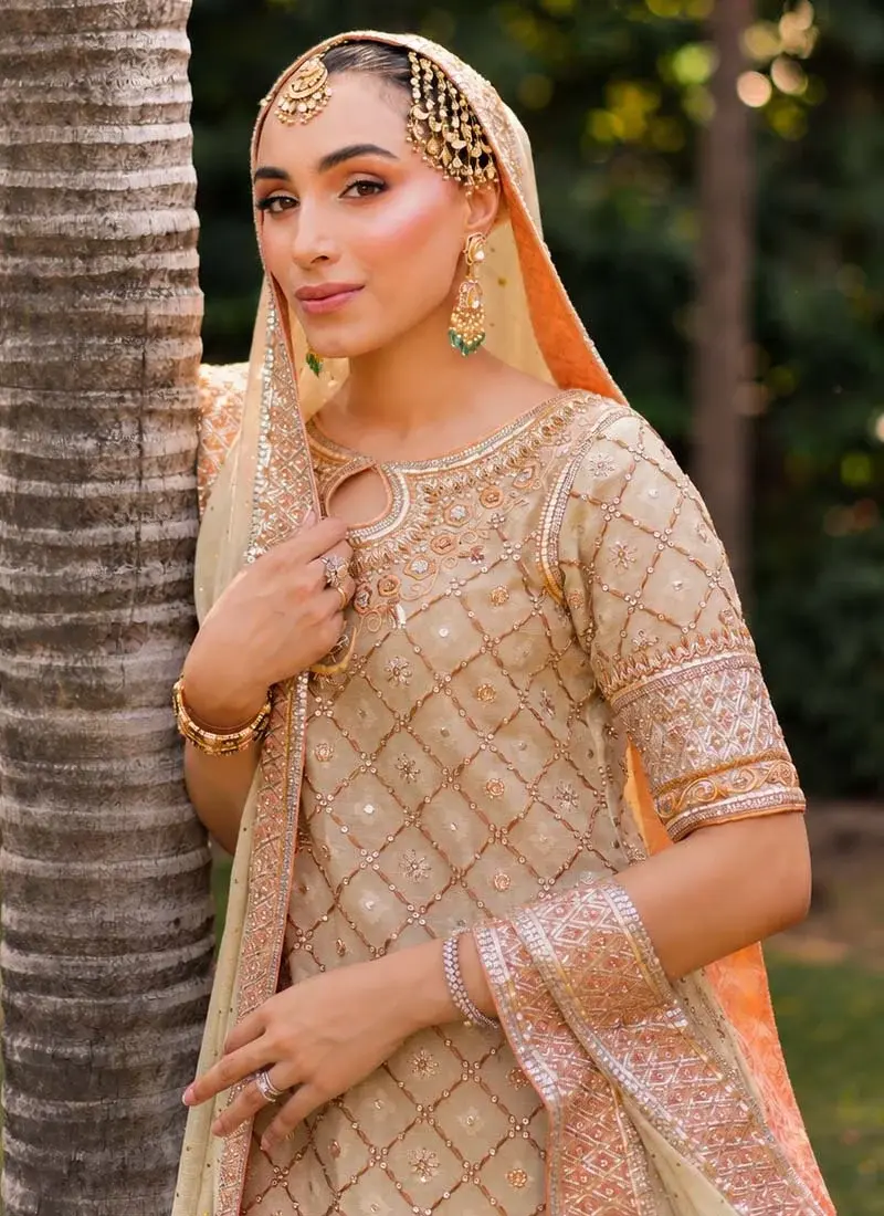 Ivory sage formal long shirt suit seated full view with narrow trousers and a long peach-bordered dupatta