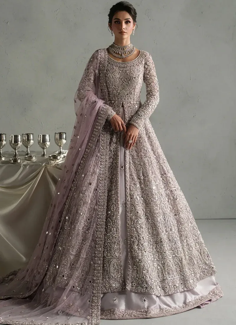 Lilac Nikkah Gown with Arched Floral Hem Dusty lilac bridal gown, back three-quarter view with dense silver embroidery and sheer bordered dupatta