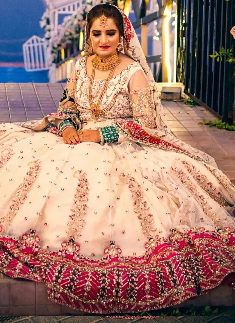 White Nikkah gown, seated front view showing embroidered bodice and scalloped fuchsia floral hem